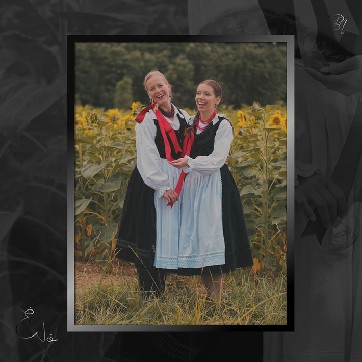 Két nő népviseletben napraforgók között. Bánhalmi Norbert fotókiállítás Bécs.