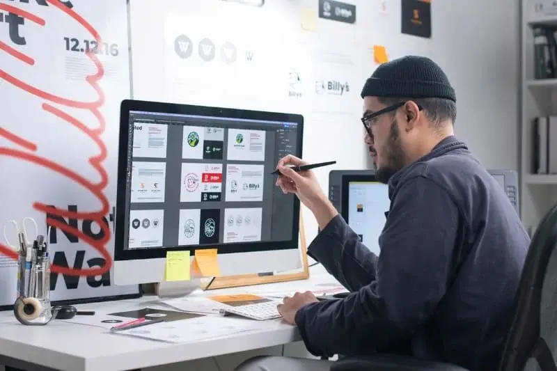 Designer desenvolvendo um logotipo minimalista no computador.