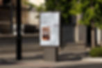 A street billboard displaying a poster that reads "next project intake, July 2026" with an image of the Peter Bouchier website displayed on a laptop.
