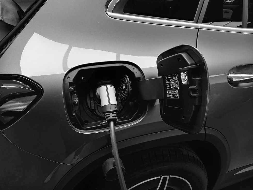 Close-up of an electric car charging, with the plug inserted into the open rear charging port.