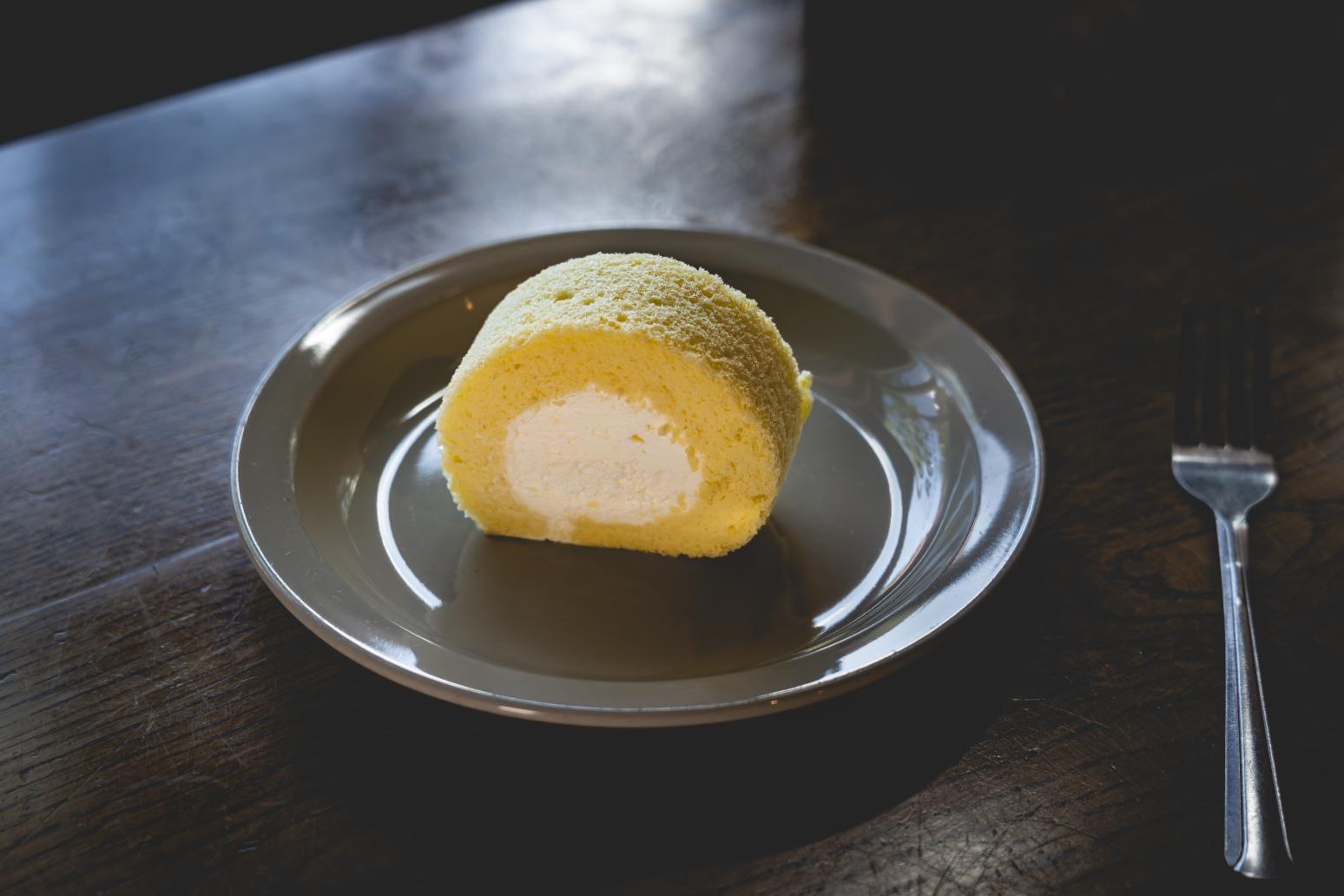 A slice of Kumo Cake Studio roll cake on a metal plate