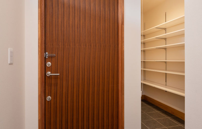 ご主人がこだわった木製の玄関扉を採用。右側がシューズクローク。