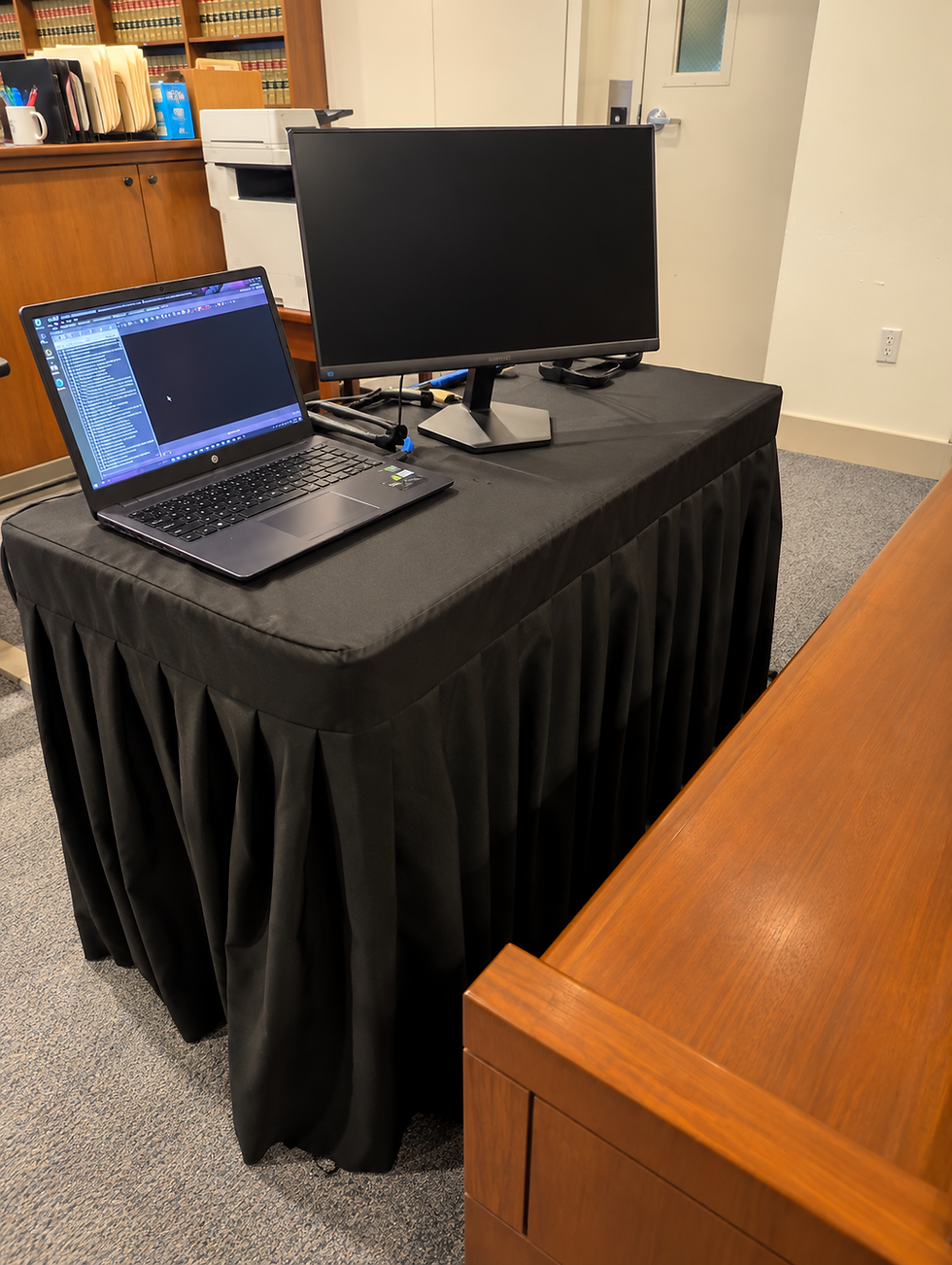 Trial tech courtroom setup with laptop and external monitor prepared for electronic evidence presentation