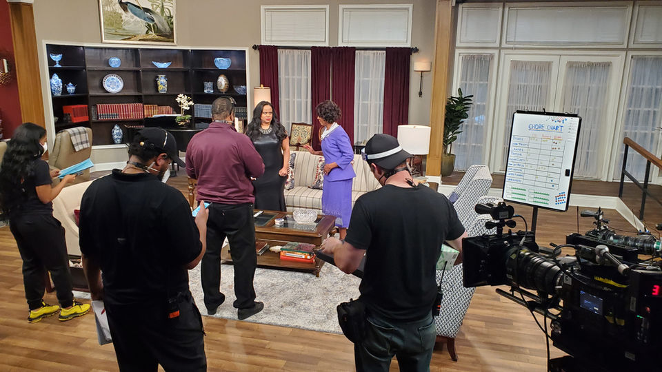 An image of Alretha Thomas on the set of Tyler Perry's "Assisted Living" with director Derrick Doose