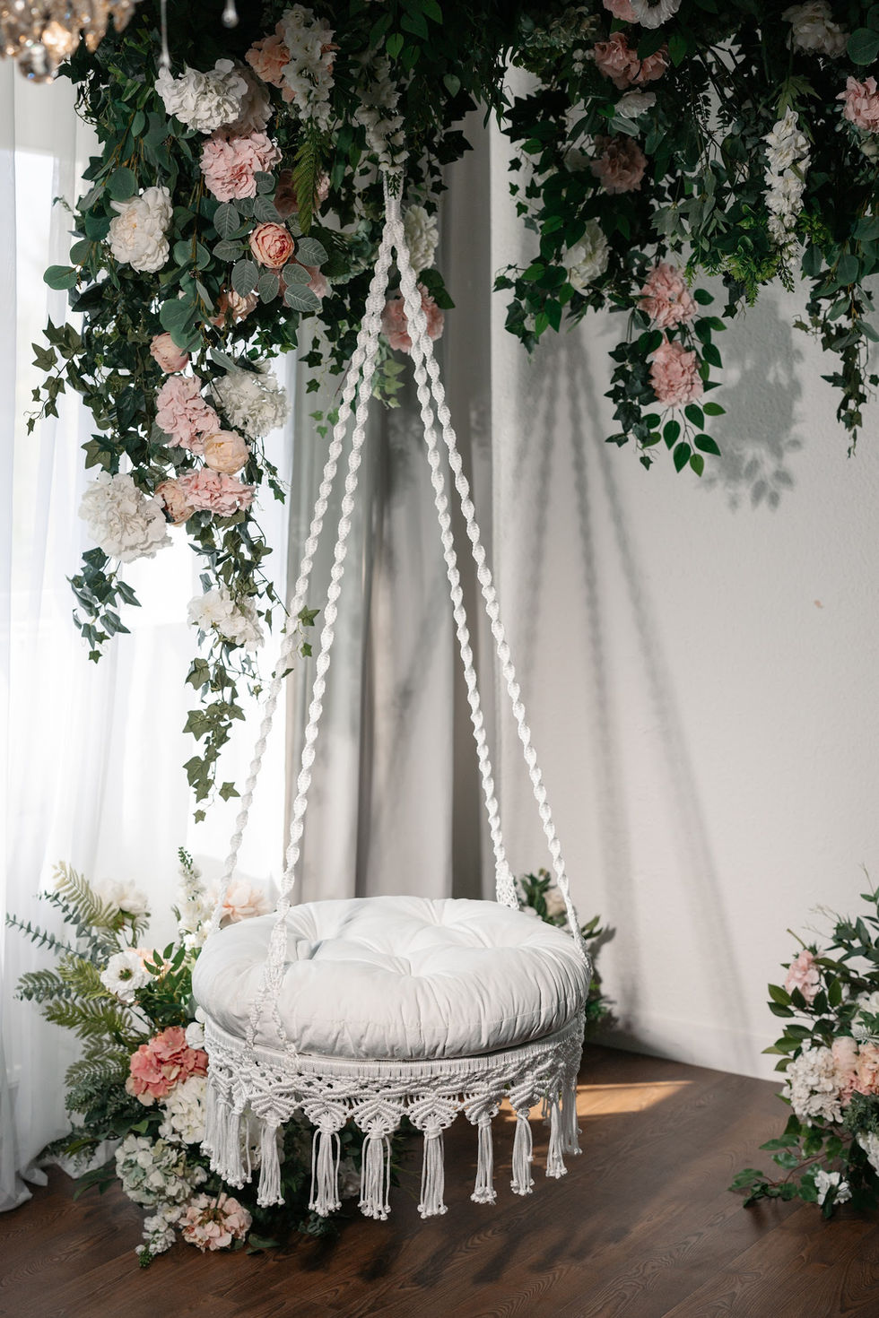 White macramé hanging chair with soft cushion in interior setting, decorative hanging swing chair, boho style statement chair for home by Salviri.