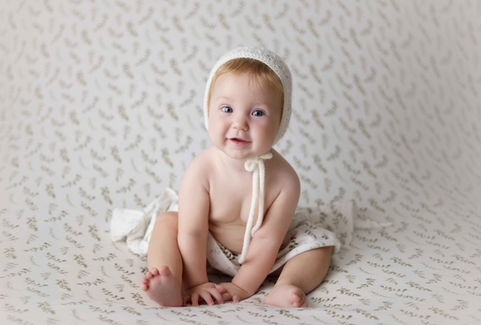 Fotógrafa de bebés en Alcoy y Alicante, imagen de un bebé de 6 meses sonriendo en estudio profesional.