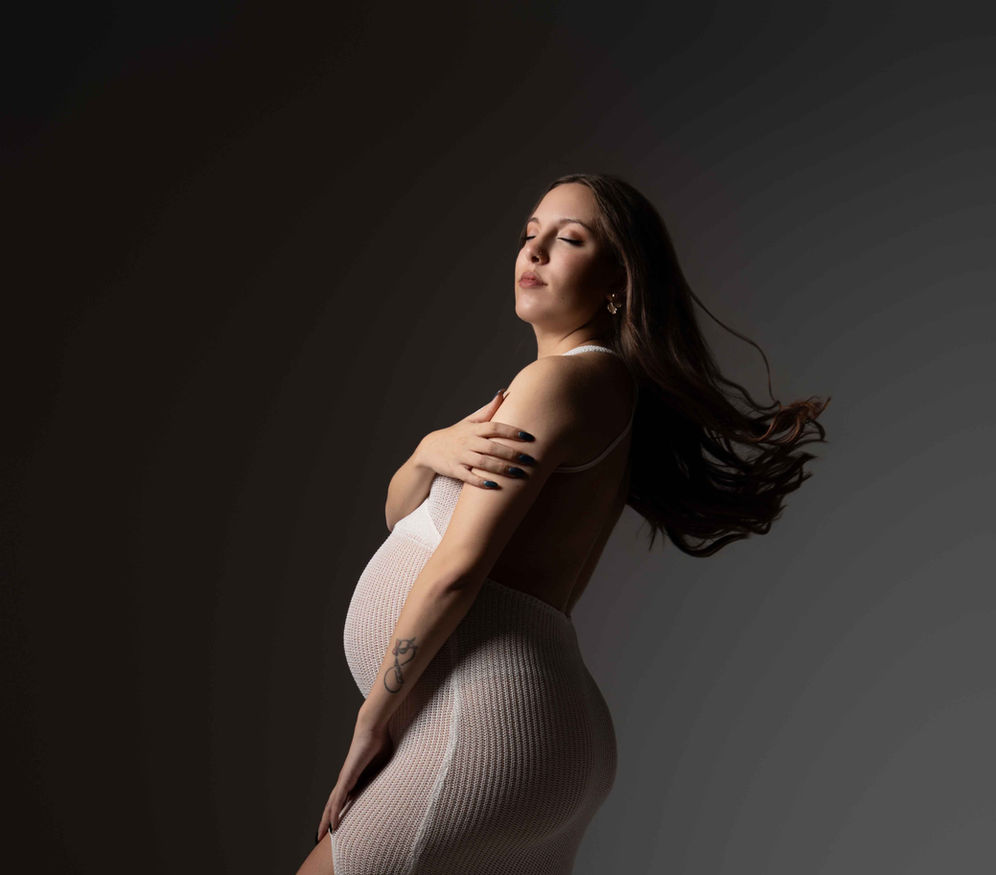 Sesión de maternidad en estudio en Alicante con iluminación cuidada.