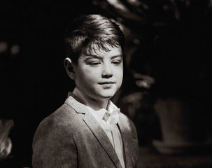 Niño/a en sesión de comunión en un bosque con luz natural en Alicante.