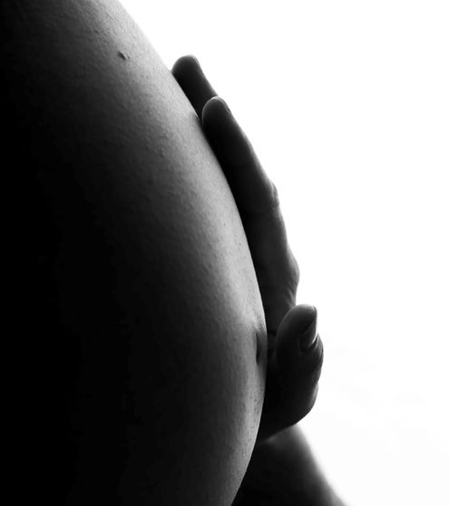 Fotógrafa de embarazo en Alcoy y Alicante, imagen de una mujer embarazada en sesión de fotos profesional en estudio.