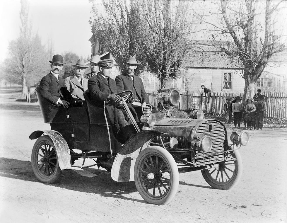 Historic black and white photo of the foundsers of D.L. Evans Bank in a model T Ford