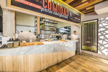 Mostrador de bar con letrero 'Comidas para compartir'