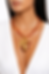 femme portant un collier en acier doré avec perles ambrées et pendentifs cœur et croix porté