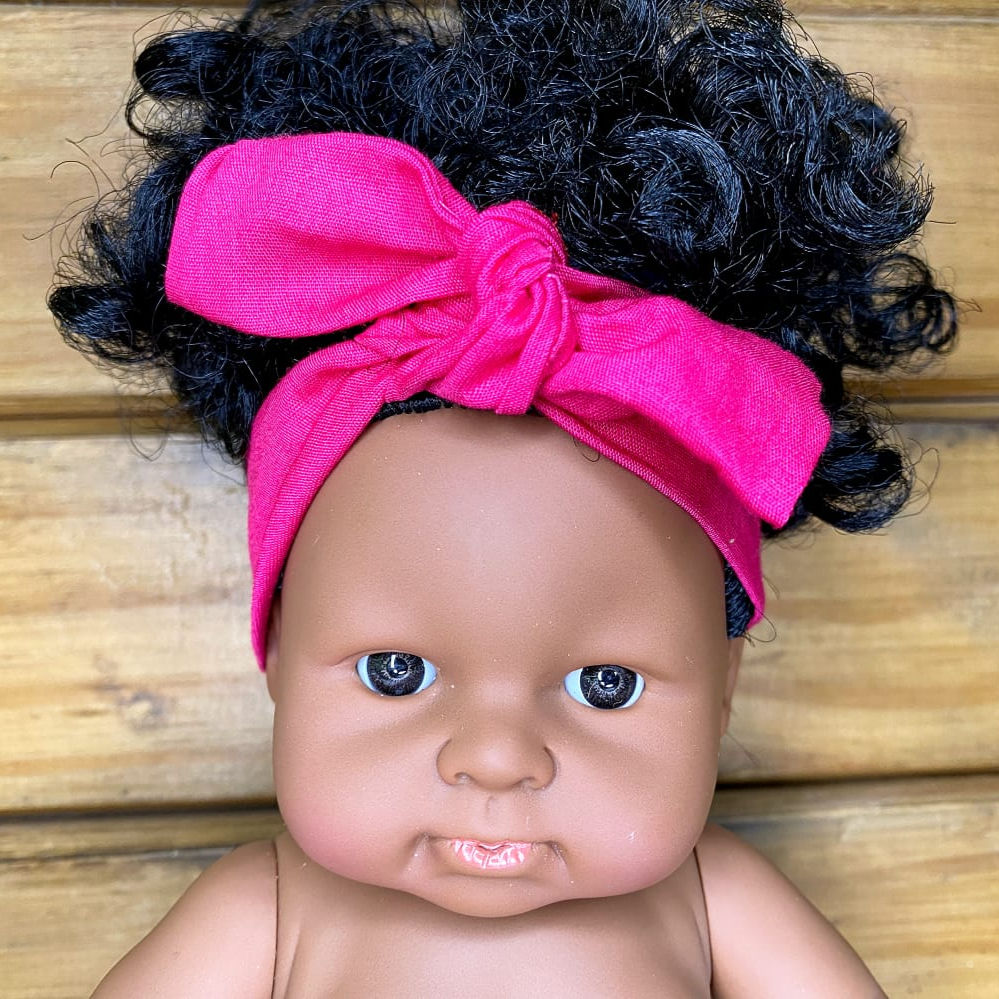 Bandeau rose fuchsia pour poupée, accessoire élégant avec nœud ajustable.