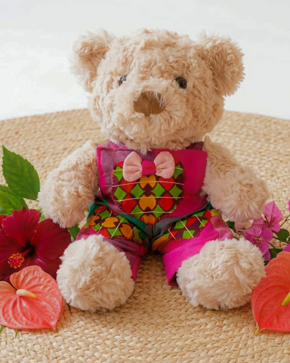 Peluche ourson beige en fourrure bouclée avec salopette fuchsia et cœur en tissu wax faite main en Martinique - Doudou pièce