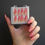 Thumbnail: hand holding box of pink and orange ombre coffin press on nails