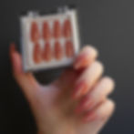 hand holding box with sheer peach colored press on nails