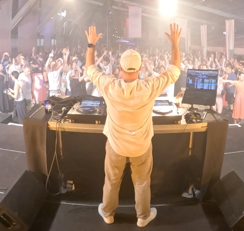 DJ Carlos Rivera spielt vor voller Tanzfläche bei einem Event