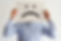 "Person holding a large paper with a sad face emoticon in front of their head, symbolizing dissatisfaction or negative feedback.