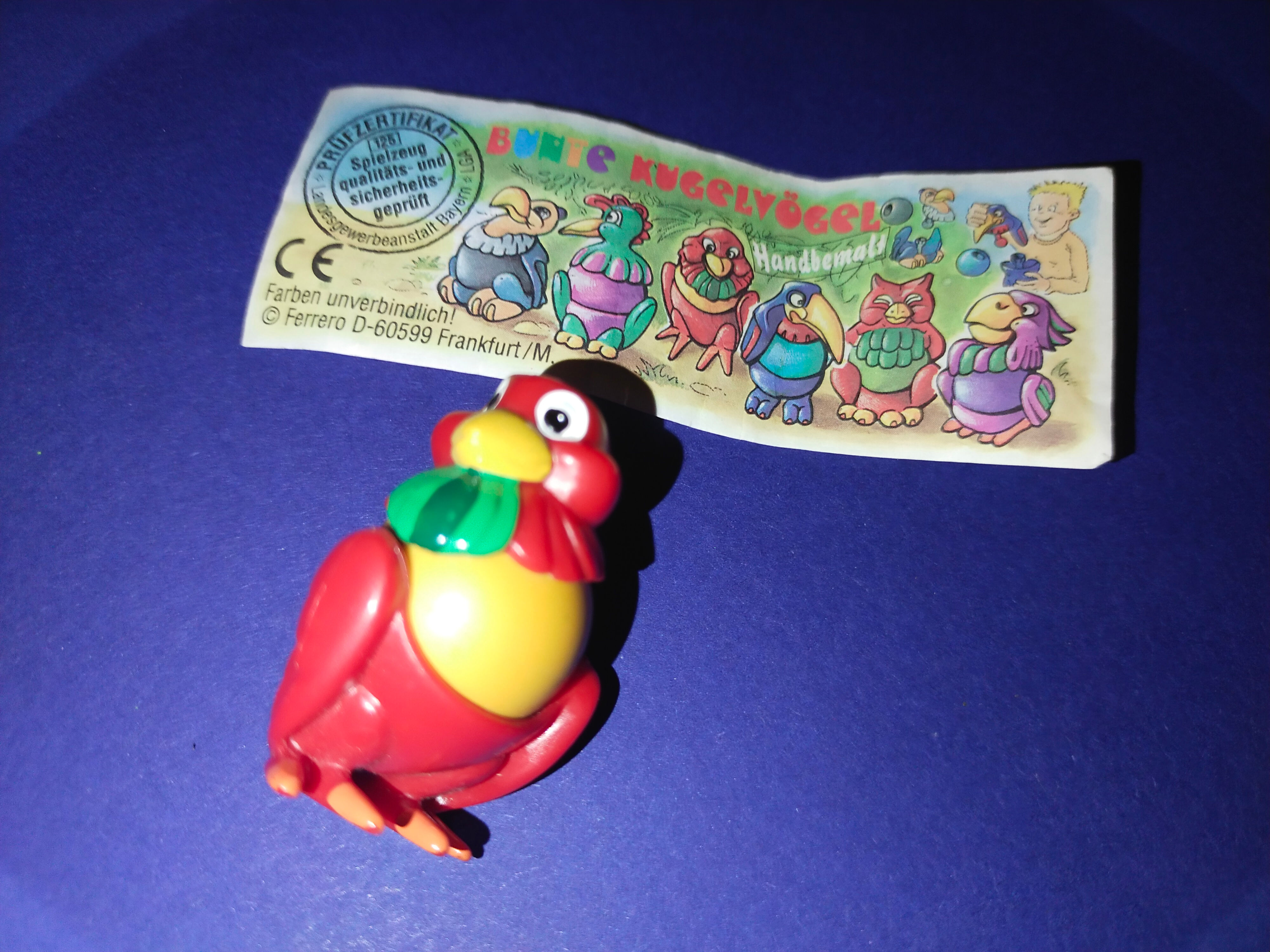 Červený papoušek, hračka Tinas und Toms galaxis