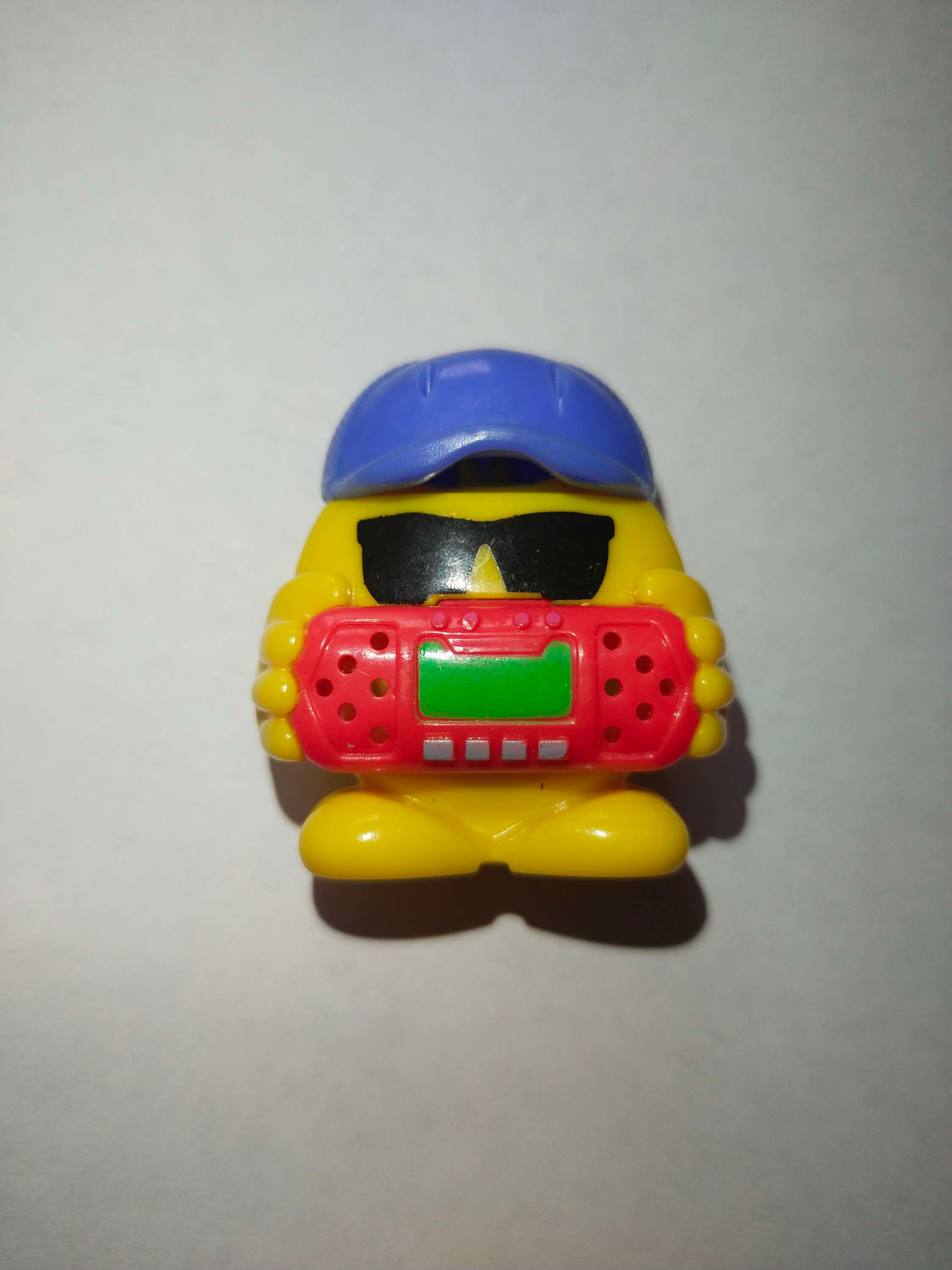 Žlutá hračka v čepici a brýlích