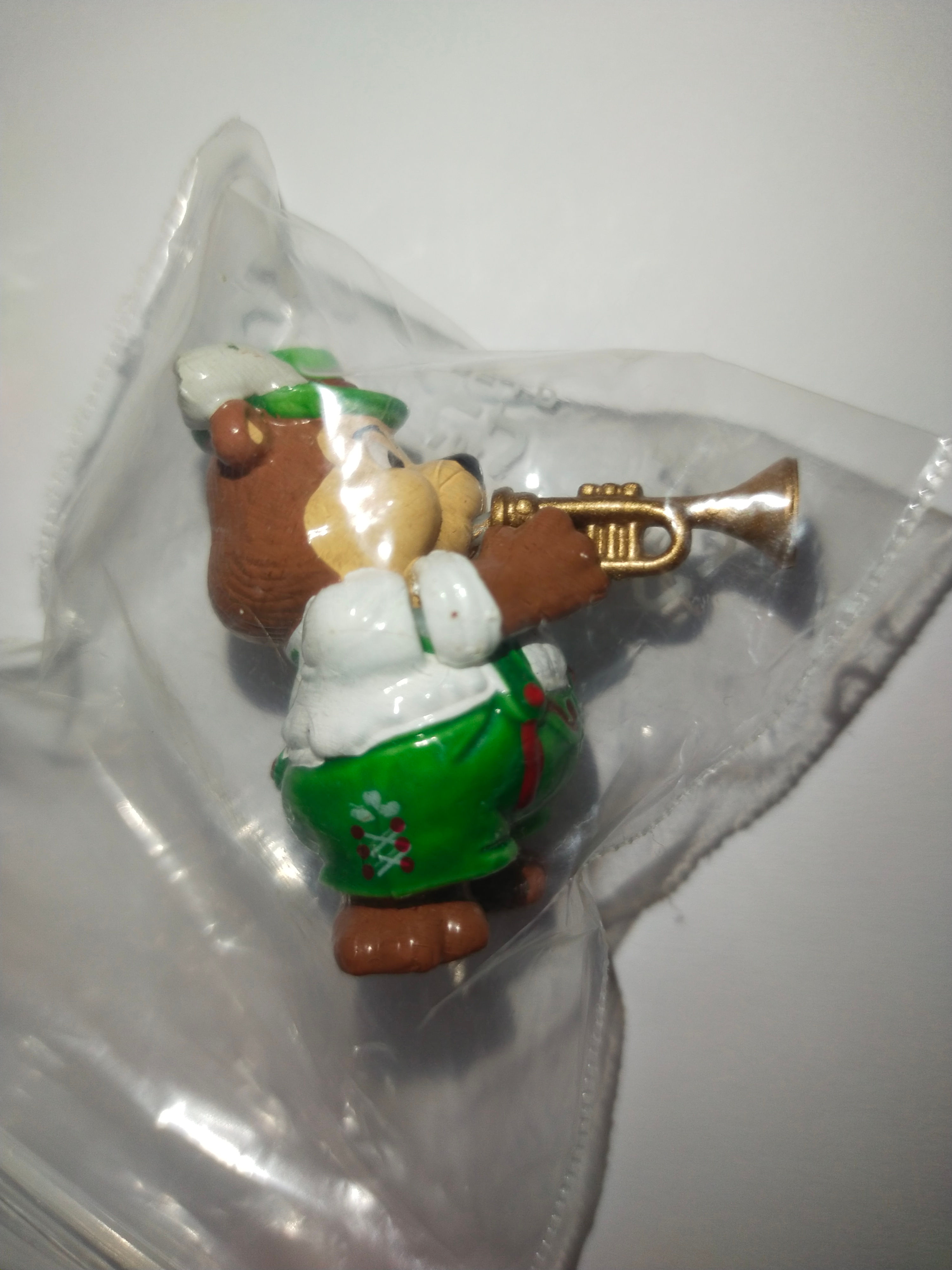 Figurka medvěda hrajícího na trubku