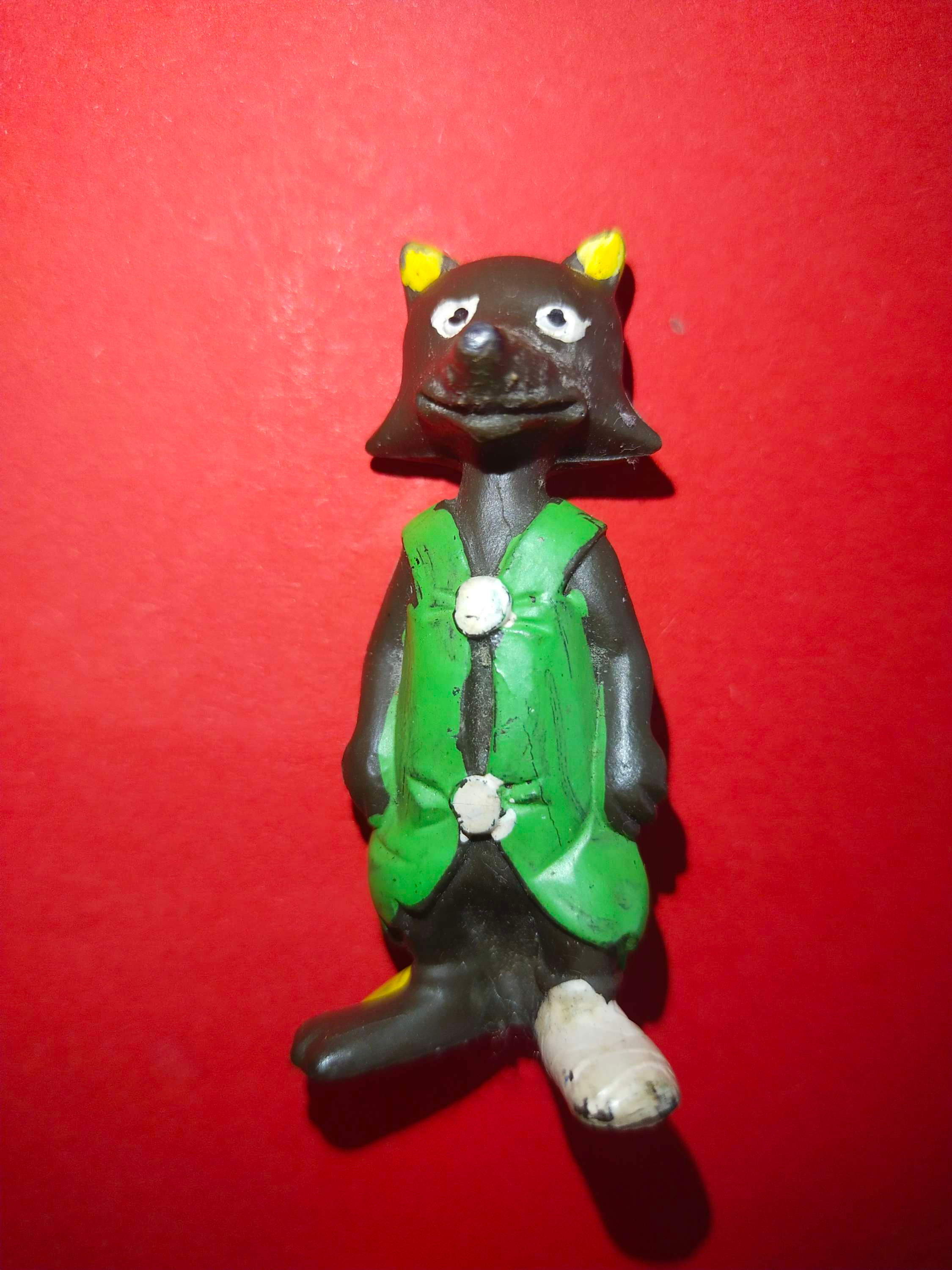 Figurky černého vlka v zelené vestě