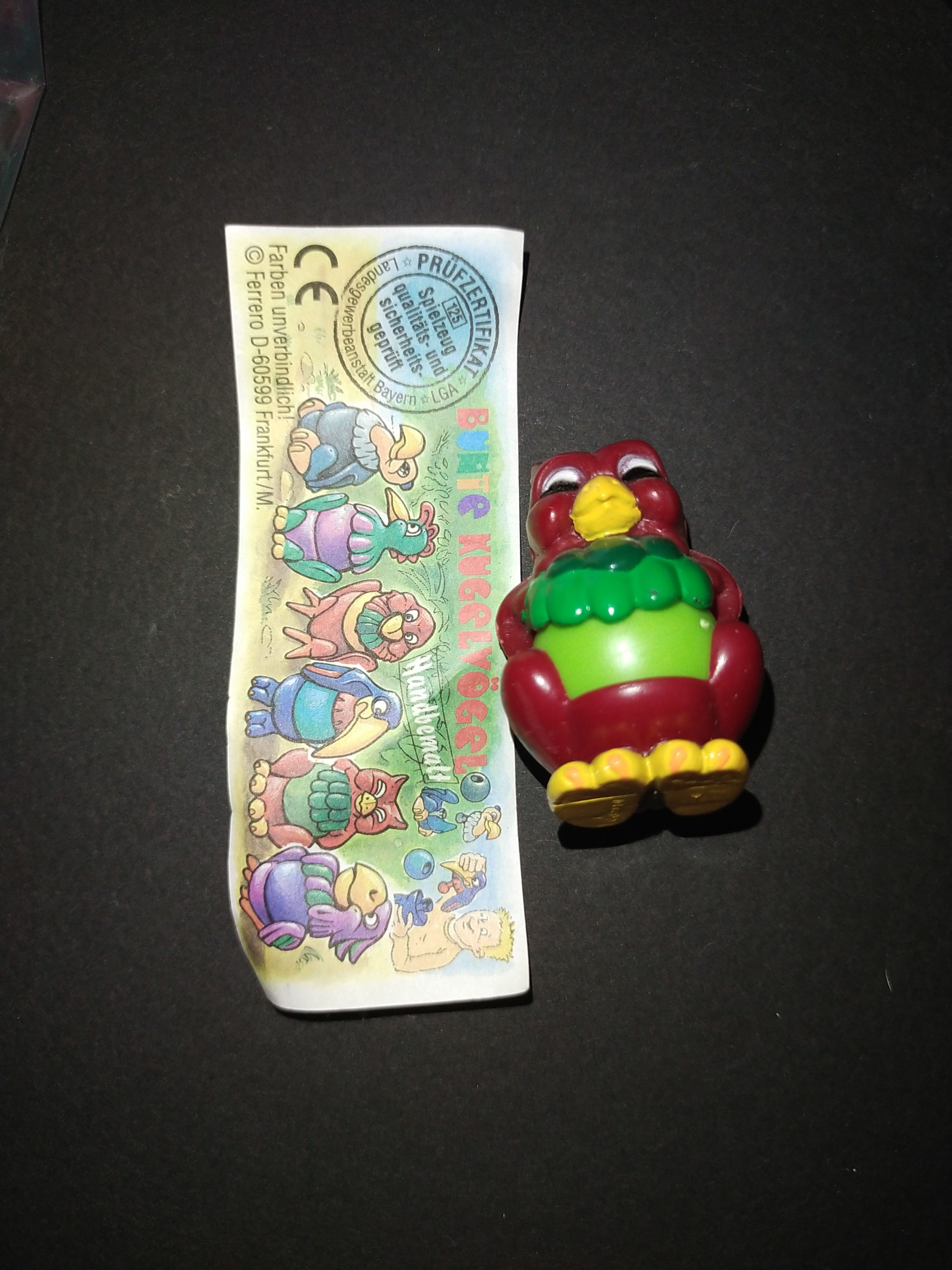 Hnědý a zelený hračkářský pták s obrázkem dalších figurek