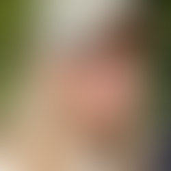 Martha wearing a grey cap smiling. She has long blond hair and is wearing a white t shirt.at the camera. S