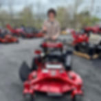 Koda Tolppa standing next to a commercial lawn mower