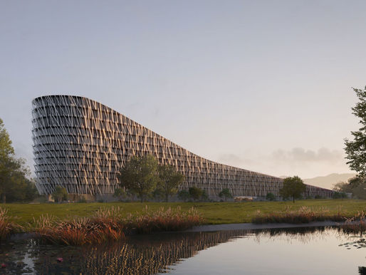 Modern building with a wavy, lattice-patterned facade in a serene park setting. Trees and a pond with lilies in the foreground at sunset.