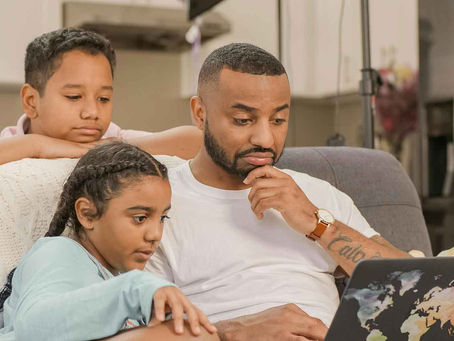 A father reviewing research about homeschool methods with his children