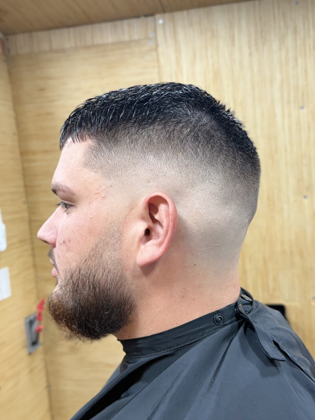 High skin fade with shaped beard, left side view