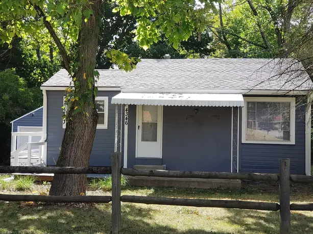 Freshly painted navy-blue house with white trim and awning in Dayton, Ohio, exterior painting project by Tech Pro Construction