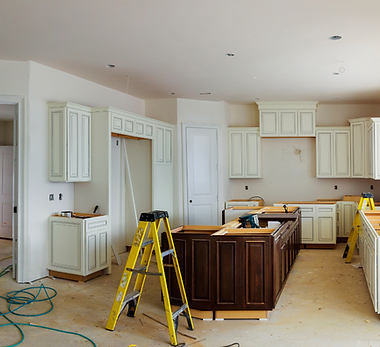 Drywall installation project with exposed joint compound, hard hats, blueprints, and construction tools on a wooden table.