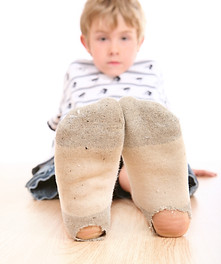 Boy wearing dirty socks with holes in th