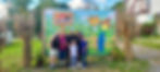 Family posing at the corn maze sign