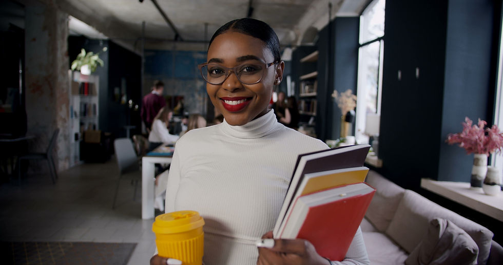 woman educator and leader holding books and a coffee