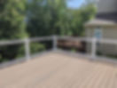 Wood deck installed on a front porch with natural stained finish