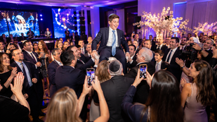 Un chico en su bar mitzvah en su fiesta mientras le sacan fotos para el album compartido
