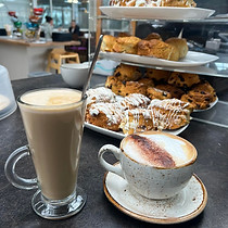 Hot and cold coffee with pastries on a table.
