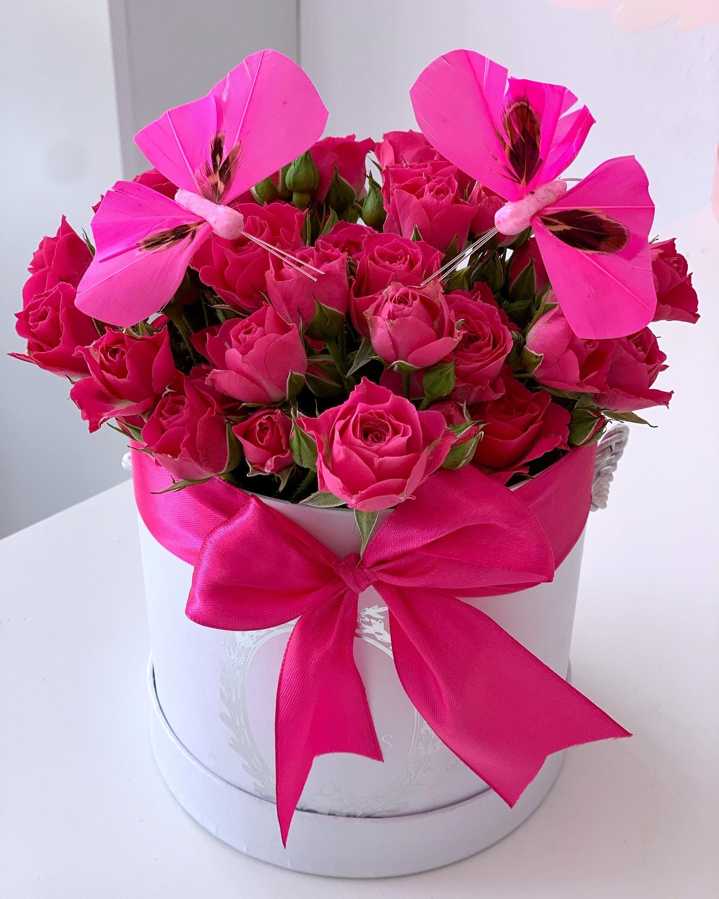 Fuchsia bush roses in white box 