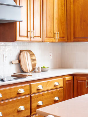 Updated 90s kitchen with black island, custom hood, and modern finishes