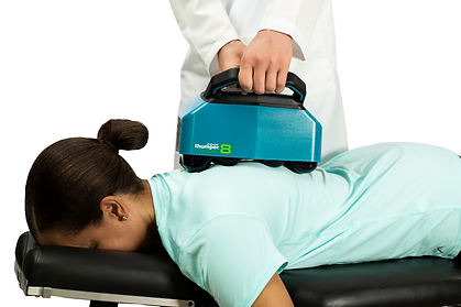 Therapist applying Thumper massager on patient’s upper back for deep tissue therapy.