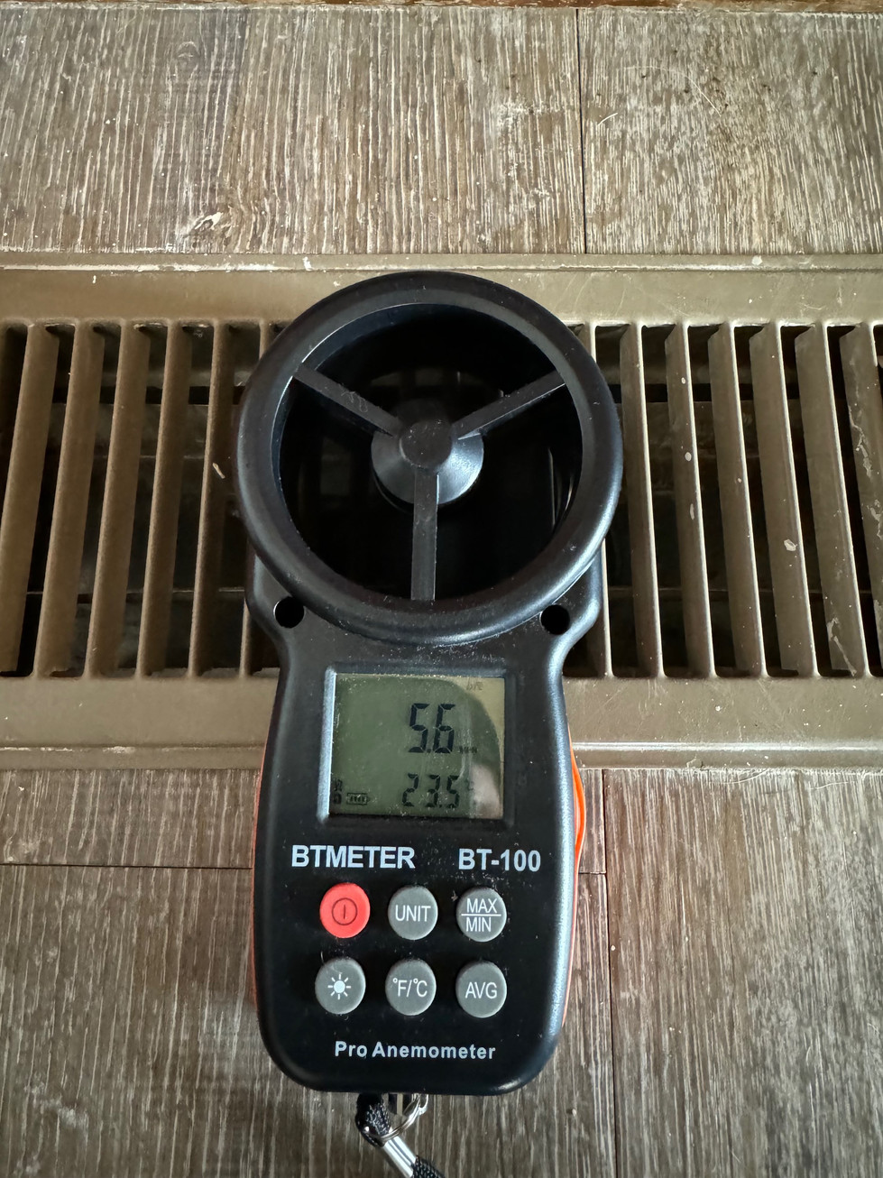 a btmeter is sitting on a heating/cooling register with a reading of 5.6 mph before cleaning