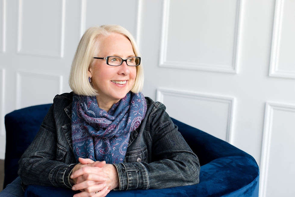 Photo of Julie Stauch - blonde woman wearing glasses, scarf, & jean jacket