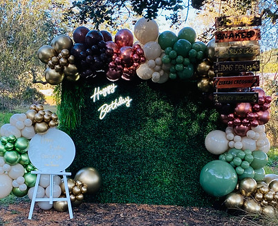 Boxwood jungle party backdrop with balloons