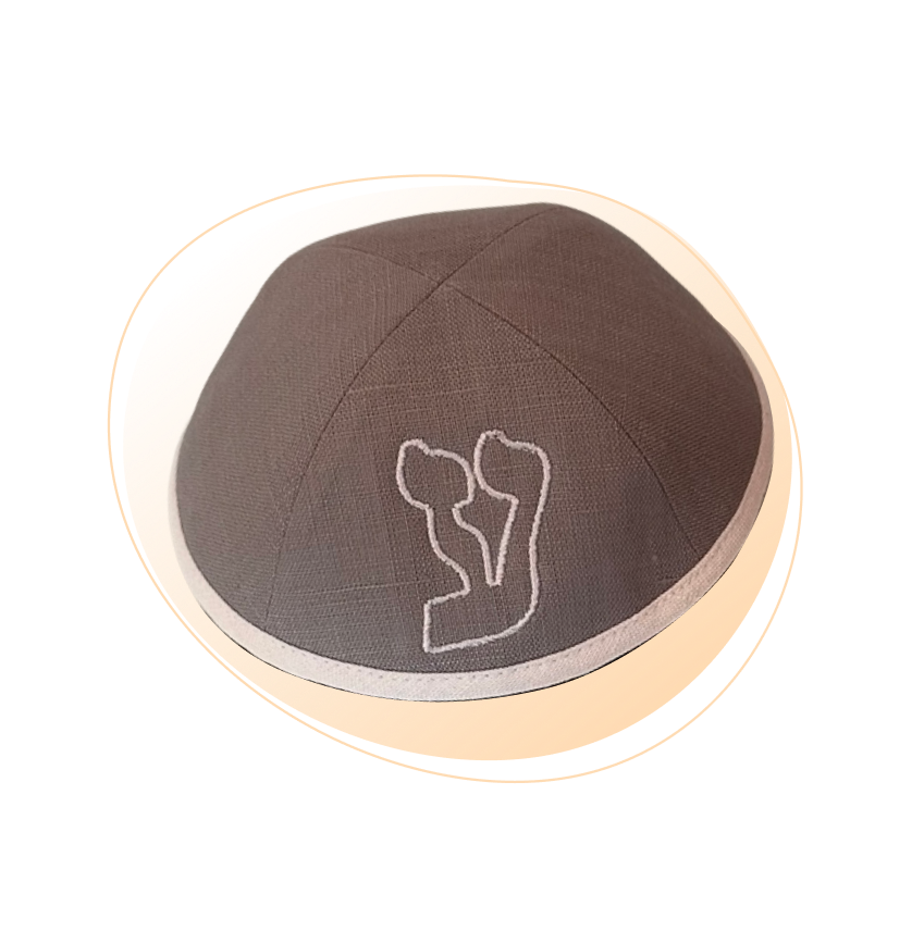 A dark brown embroidered kippah with light brown custom letter outline on the front.