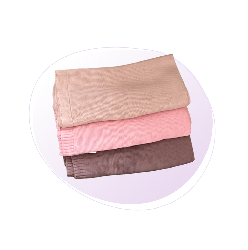 Three Crochet knit blankets folded on top of one another. From the top one it goes down to skin, pink and brown color.