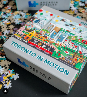 A 1000-piece jigsaw puzzle titled "Toronto In Motion," created by Arcadia Puzzles and illustrated by Toronto-based artist Rosey Cheekes.
The puzzle captures the essence of Toronto, Canada, featuring the city's most recognizable landmarks such as Ontario Place, CN Tower, Rogers Centre, and the Royal Ontario Museum.
The colourful and vibrant artwork highlights various modes of transportation in the city like the Go Train, streetcars, and local taxis.
The scene is further brought to life by the inclusion of local wildlife, such as raccoons, pigeons, and Canada geese.