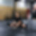 Robert Dobai in a seated straddle stretch, opening the hips, in the gym.